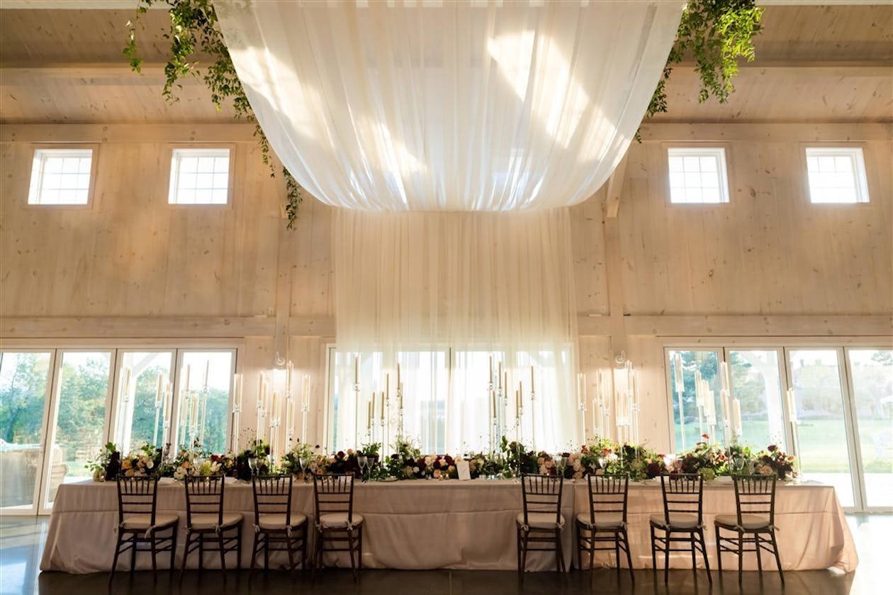 Elegant summer wedding with white ethereal ceiling drapery | PartySlate