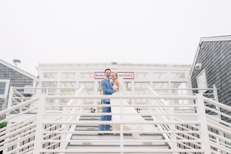 nantucket wedding at The Sankaty Head Beach & Golf Club with couple standing on stairs | PartySlate