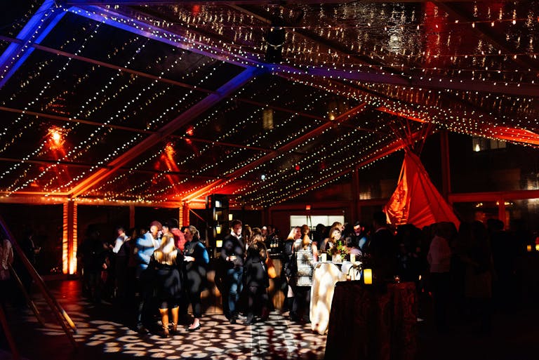 WIPA event in colorado with outdoor tented dance floor with string lights hung above dance floor | PartySlate