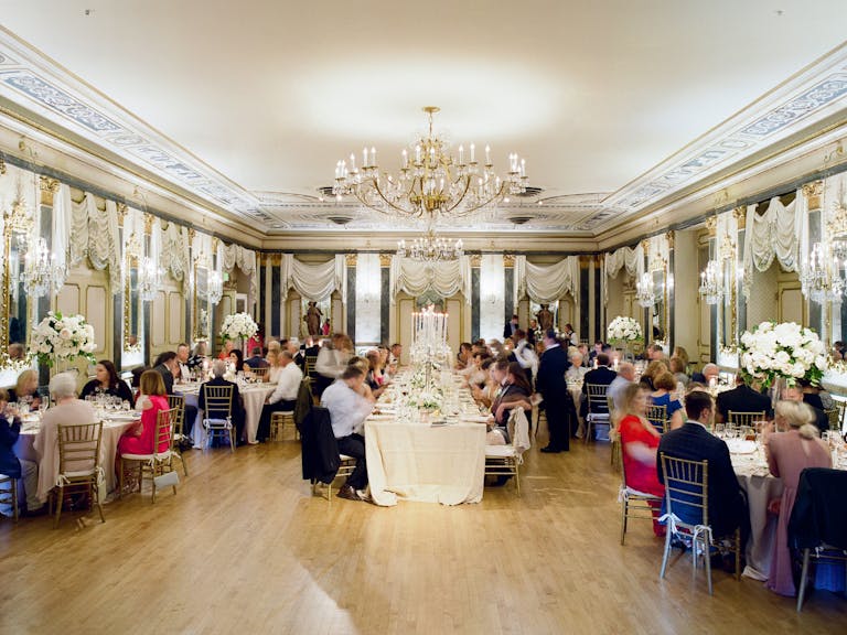 indoor wedding reception in colorado with classical decor and architecture and guests seated at tables | PartySlate