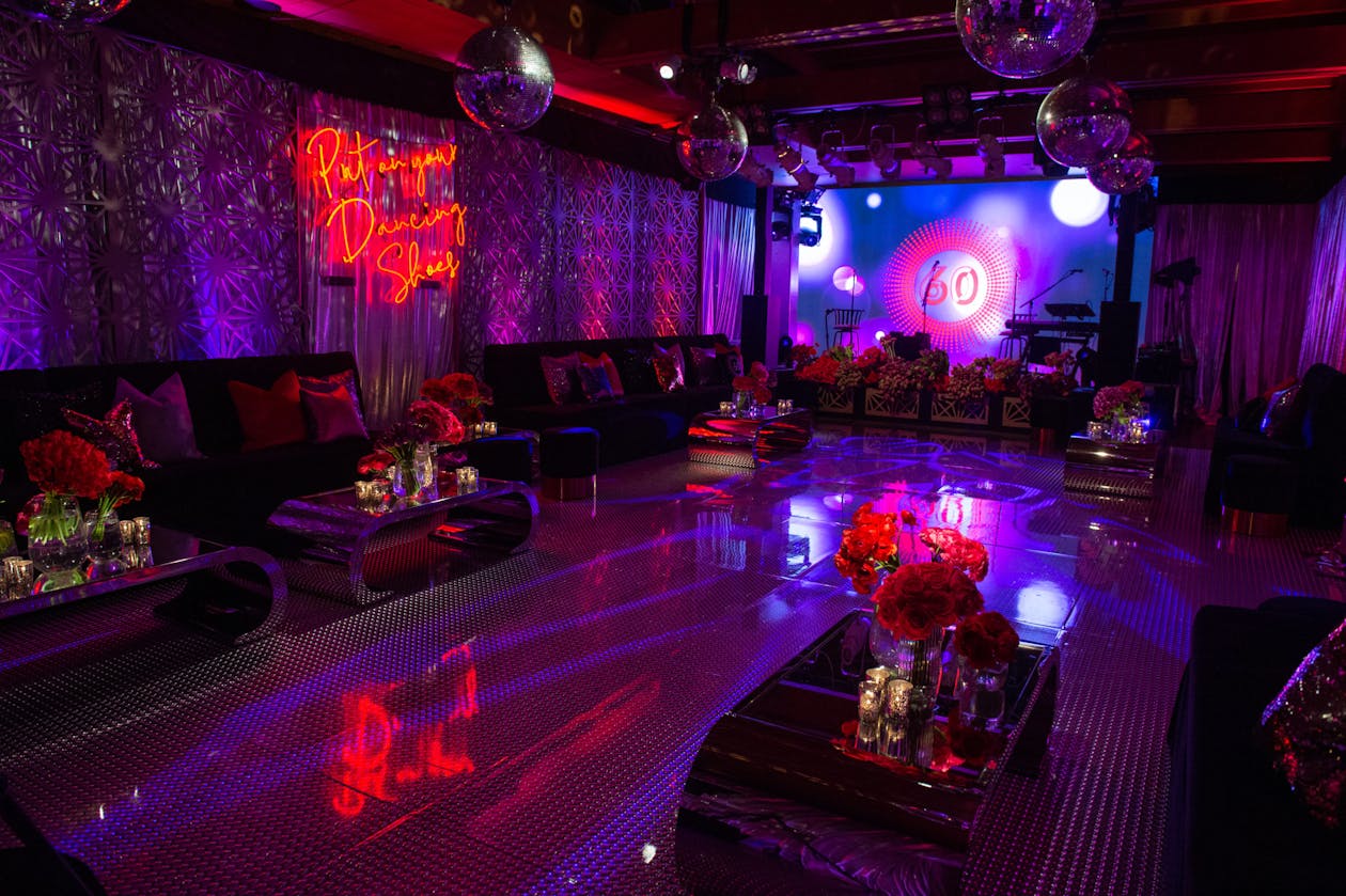 disco themed 60th birthday party with neon lights and a dance floor | PartySlate
