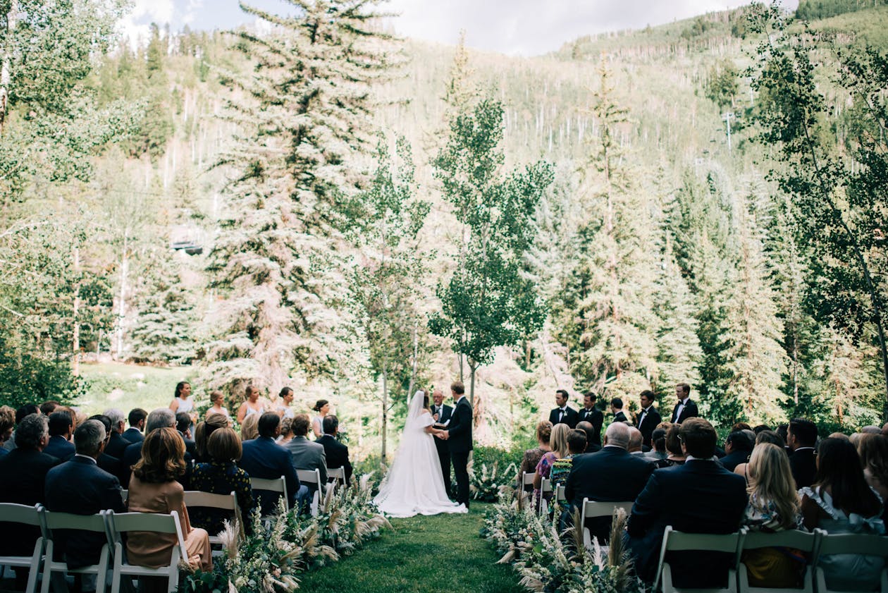colorado mountain wedding venue with bride and groom at outdoor alter with guests seated | PartySlate