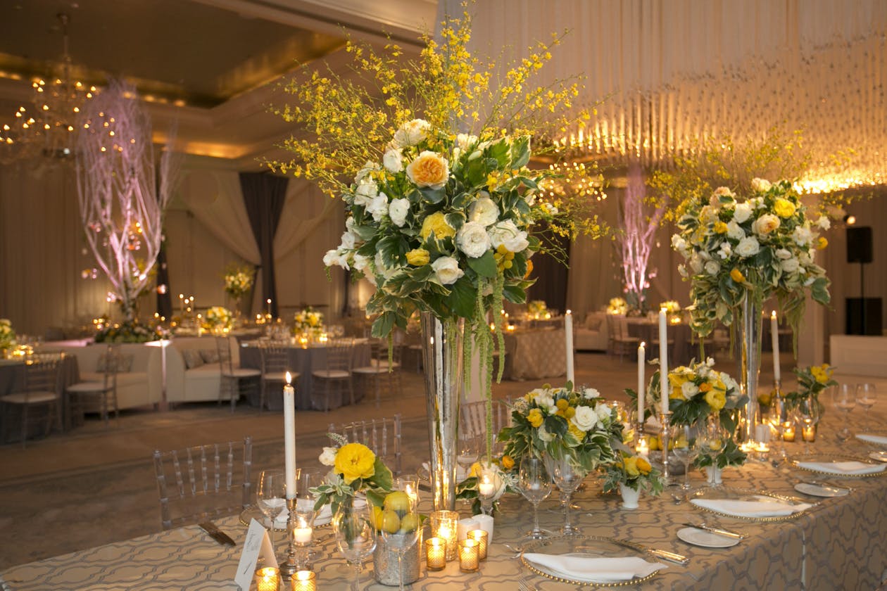 Summer wedding with bright yellow flower centerpieces | PartySlate