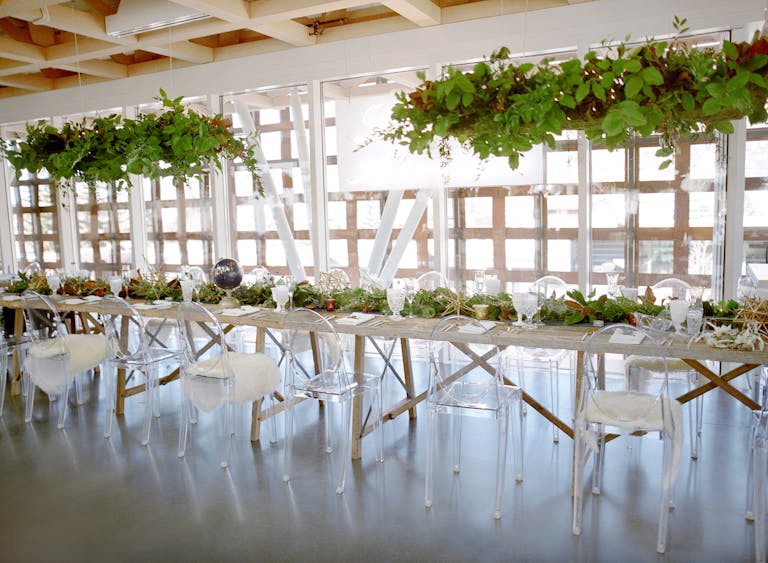 wedding at aspen art museum with long head table and greenery | PartySlate