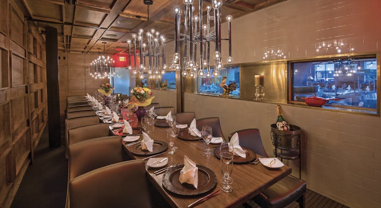 private dining space at Artisans Restaurant in houston with long rectangular table set with plates and napkins | PartySlate