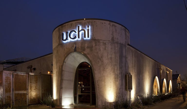 Uchi Houston exterior of restaurant at night with lights on the walls | PartySlate