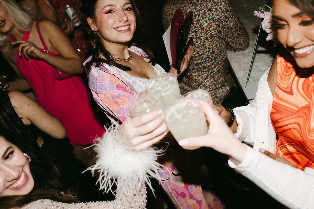 disco engagement party with guests clinking drinks wearing themed outfits | PartySlate