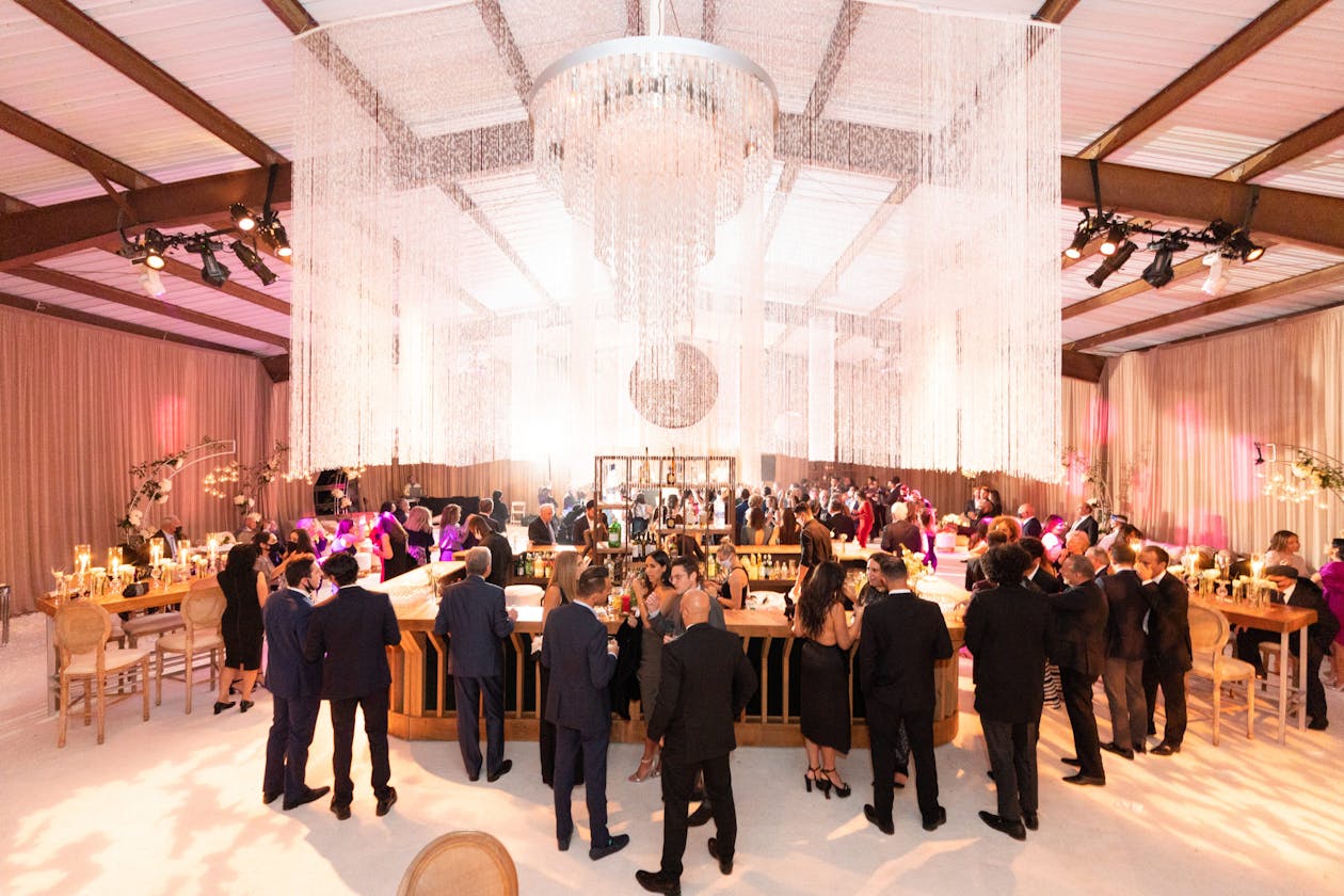 glamorous engagement party indoors with chandeliers and white dance floor | PartySlate