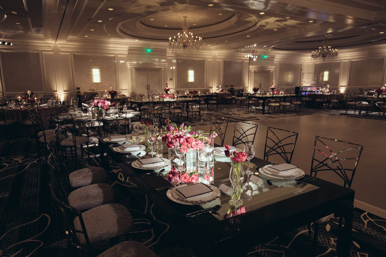 romantic engagement party with mood lighting and pink florals on tables as centerpieces | PartySlate