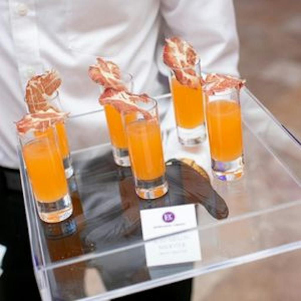 orange cocktail with bacon garnish at business anniversary party | PartySlate