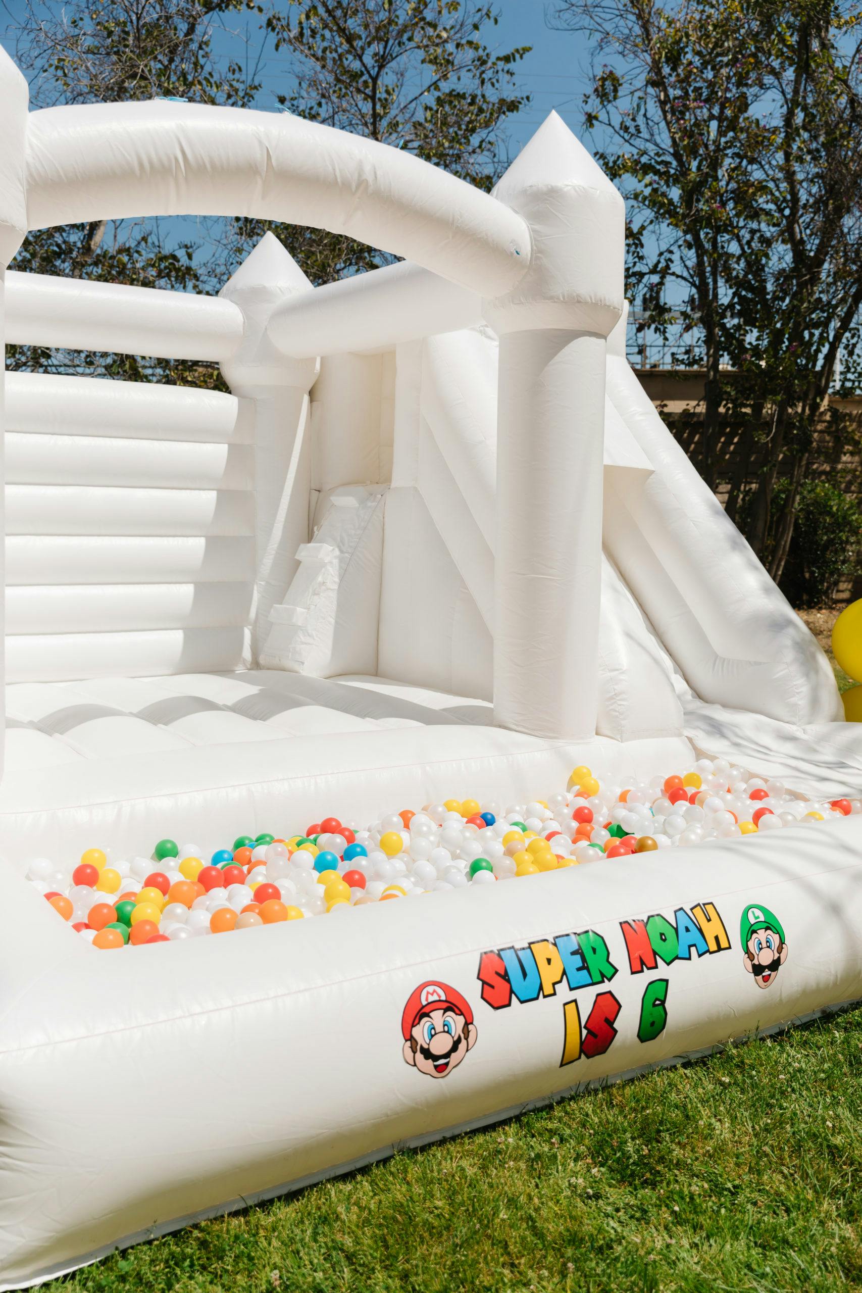 Super Noah Turns 6 with outdoor kids birthday party trend bounce house | PartySlate