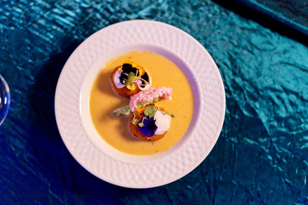 Plated dinner on metallic blue linen at South Asian wedding | PartySlate
