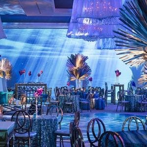 South Asian wedding reception with blue uplighting and décor.