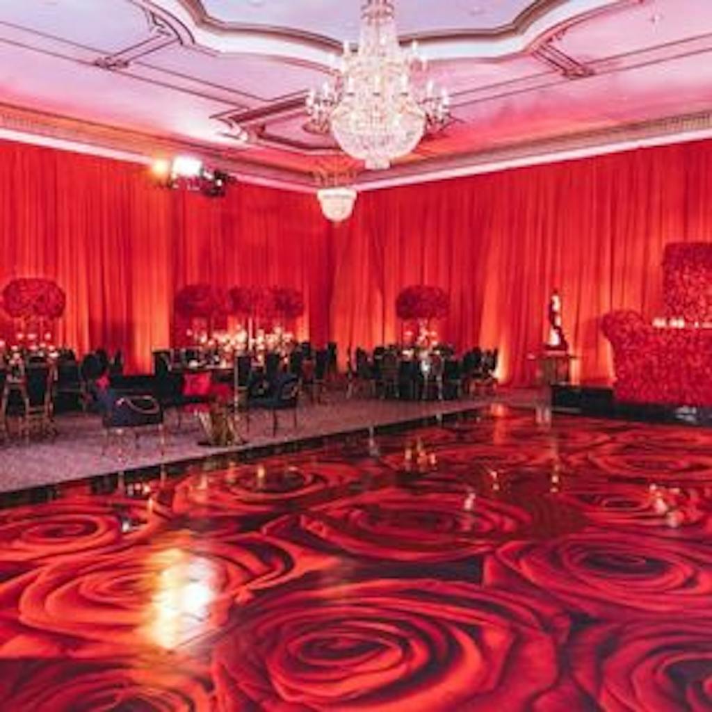 Red ballroom wedding with rose red dance floor.