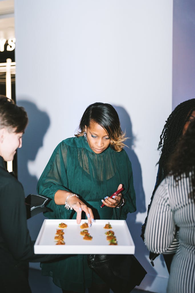 Women taking an appetizer from a tray