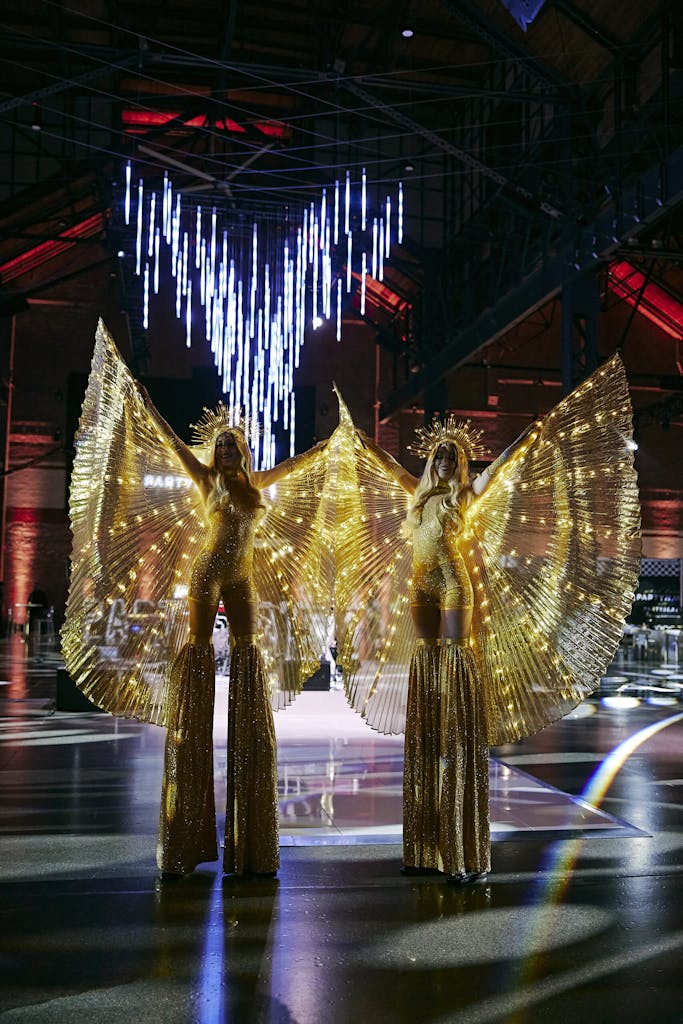 Two stilt performers in gold costumers